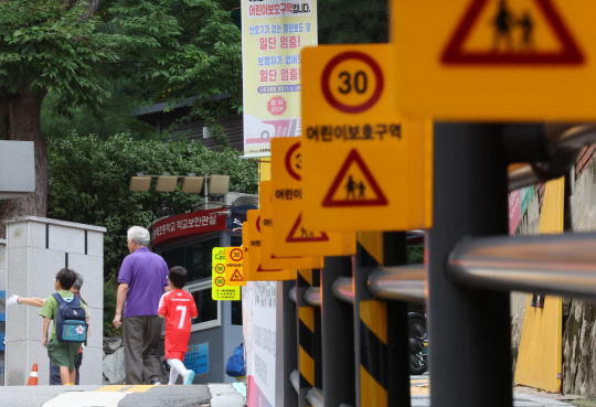 경찰이 9월 1일부터 심야 시간대 어린이보호구역(스쿨존) 속도제한을 완화하겠다고 지난 29일 보도자료 발표를 했다가 하루 만에 번복했다. 스쿨존 시간제 속도제한은 어린이 보행자가 적은 밤 시간대 간선도로에 있는 스쿨존의 제한속도를 기존 시속 30㎞에서 50㎞로 완화하는 내용이다. 사진은 31일 오전 서울의 한 초등학교 앞 설치된 어린이보호구역 표지판. [연합뉴스]